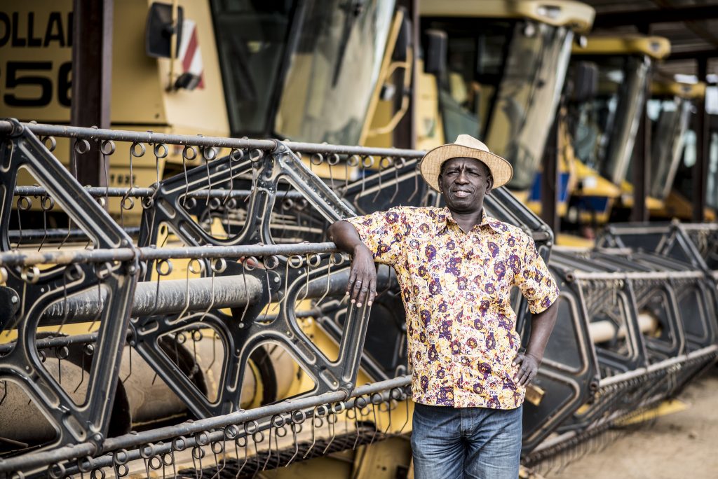 Photo of man next to harvesting equipment