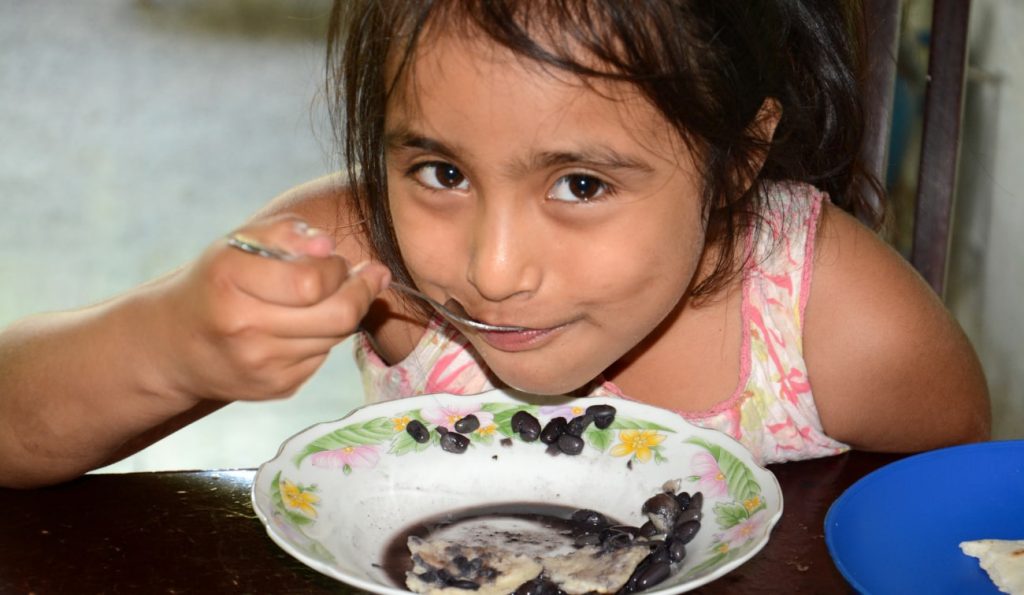 Photo of child eating beans