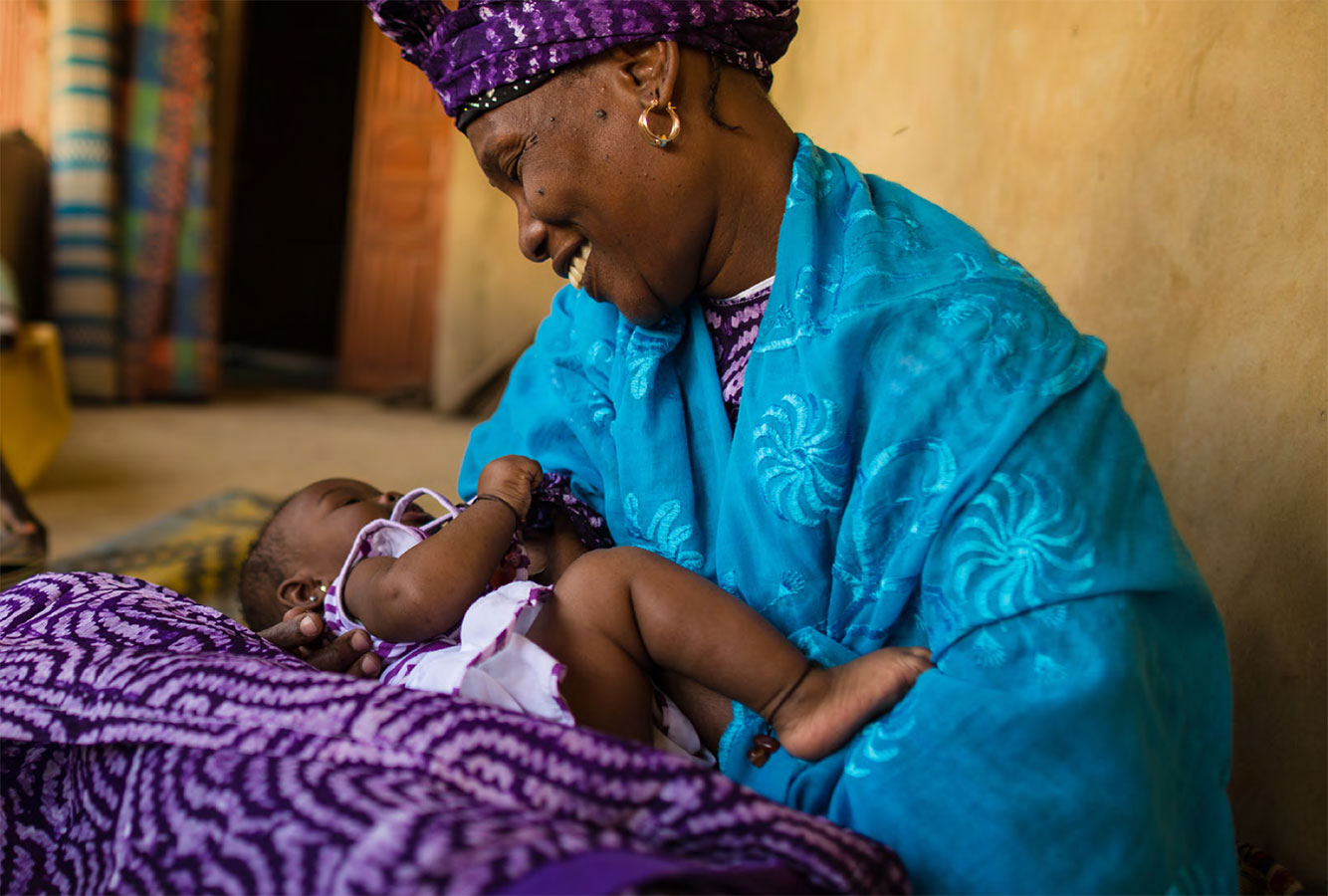 Woman smiling while holding a baby